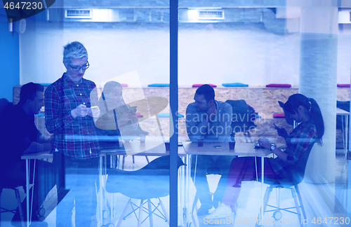 Image of business woman at office speaking by phone  team on meeting in b