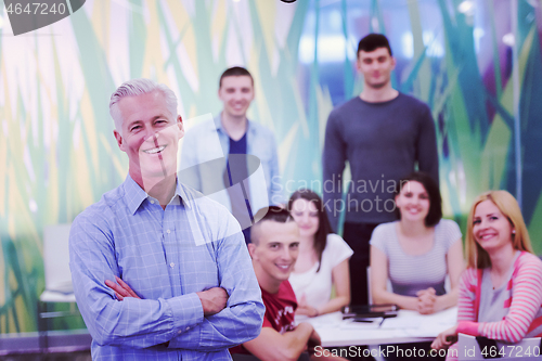 Image of portrait of  teacher with students group in background