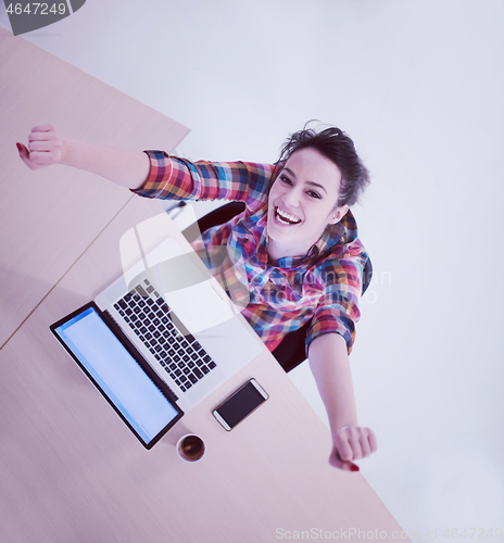 Image of top view of young business woman working on laptop