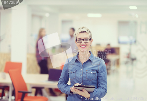 Image of portrait of young business woman at office with team in backgrou