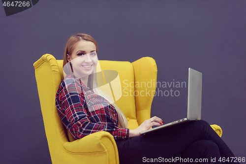 Image of startup business, woman  working on laptop and sitting on yellow