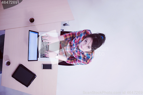Image of top view of young business woman working on laptop