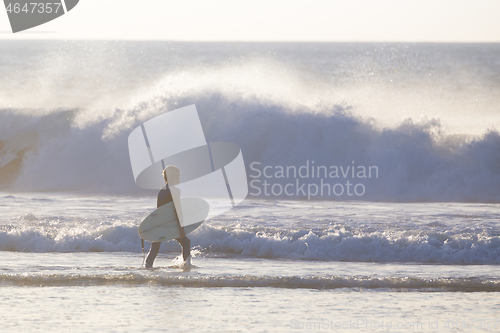 Image of Surfers on beach with surfboard.