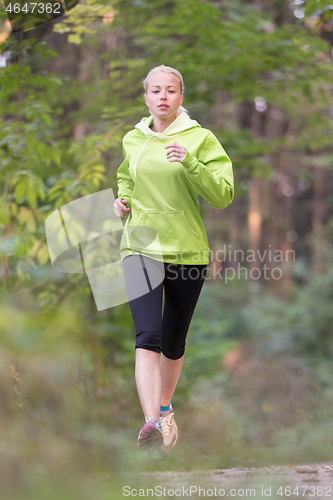 Image of Pretty young girl runner in the forest.