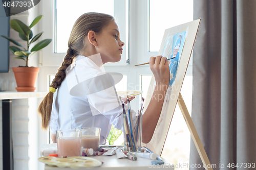 Image of Young artist draws watercolor in light studio