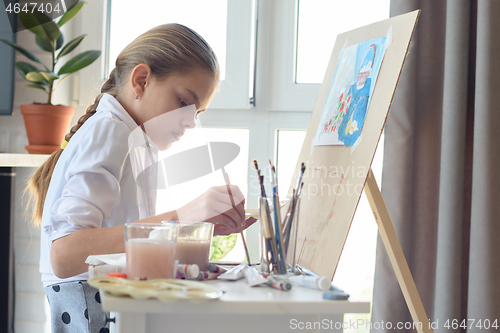 Image of Young artist draws in the studio behind an easel