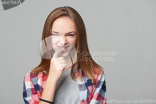 Image of Dubious teen girl thinking biting her finger