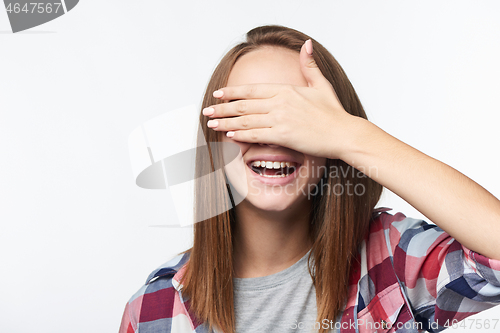 Image of Emotional happy teen girl covering her eyes with palm