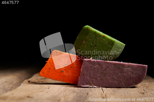 Image of Three different gourmet cheeses on rough woode planks