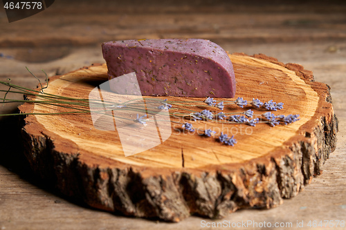 Image of Lavender cheese with bunch of fresh lavender flowers on rough wooden planks