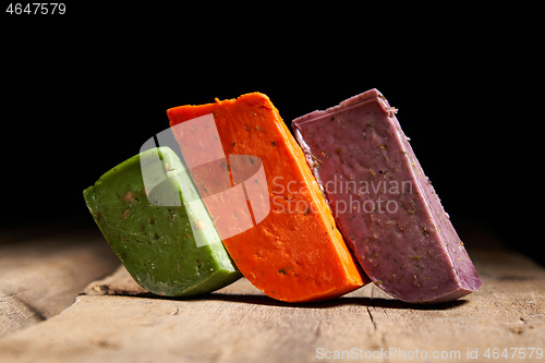 Image of Three different gourmet cheeses on rough woode planks