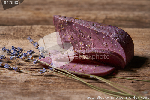 Image of Lavender cheese with twigs of fresh lavender flowers on rough wooden planks