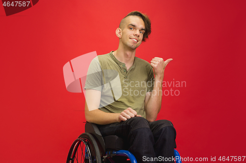 Image of Caucasian young man\'s portrait isolated on red studio background. Human emotions concept