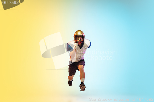 Image of American football player isolated on gradient studio background in neon light