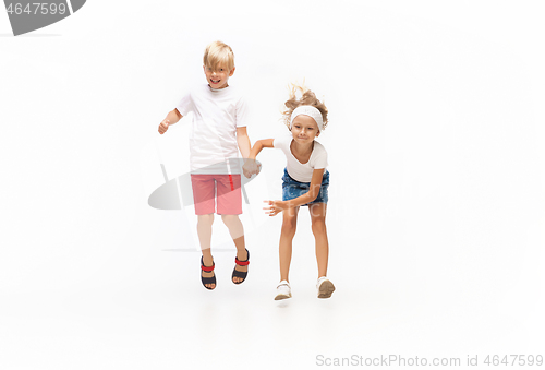 Image of Happy little caucasian girl and boy jumping and running isolated on white background