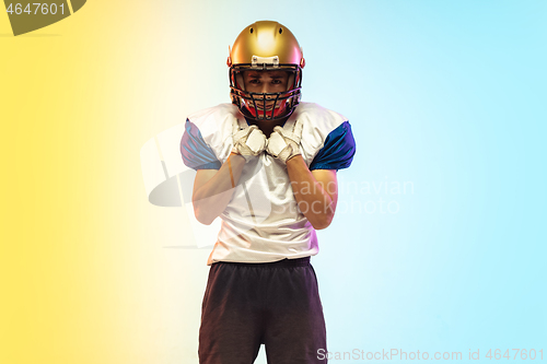 Image of American football player isolated on gradient studio background in neon light