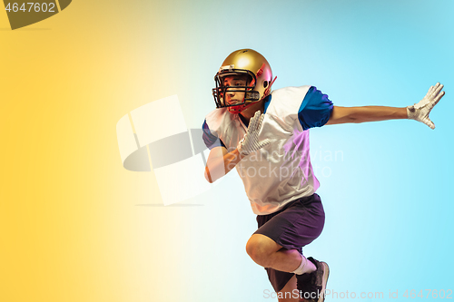 Image of American football player isolated on gradient studio background in neon light