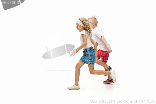 Image of Happy little caucasian girl and boy jumping and running isolated on white background