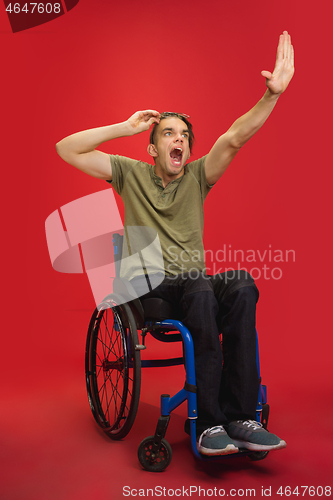 Image of Caucasian young man\'s portrait isolated on red studio background. Human emotions concept