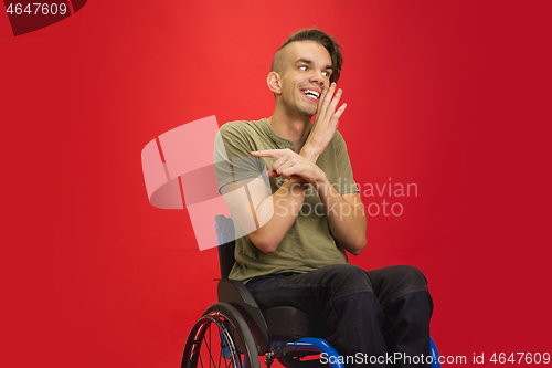 Image of Caucasian young man\'s portrait isolated on red studio background. Human emotions concept