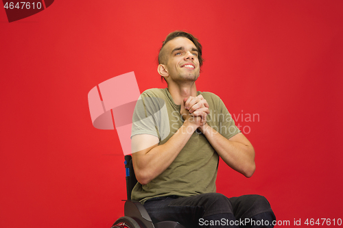 Image of Caucasian young man\'s portrait isolated on red studio background. Human emotions concept