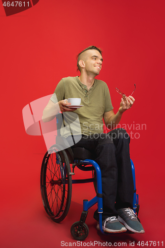 Image of Caucasian young man\'s portrait isolated on red studio background. Human emotions concept