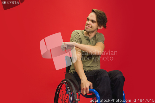 Image of Caucasian young man\'s portrait isolated on red studio background. Human emotions concept