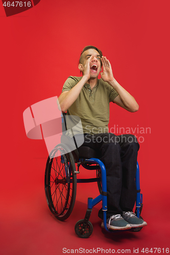 Image of Caucasian young man\'s portrait isolated on red studio background. Human emotions concept