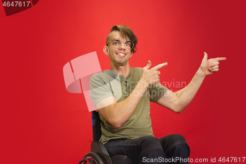 Image of Caucasian young man\'s portrait isolated on red studio background. Human emotions concept