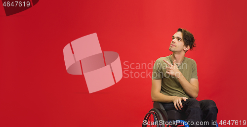 Image of Caucasian young man\'s portrait isolated on red studio background. Human emotions concept