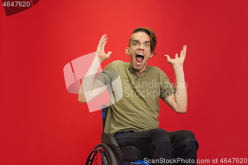 Image of Caucasian young man\'s portrait isolated on red studio background. Human emotions concept