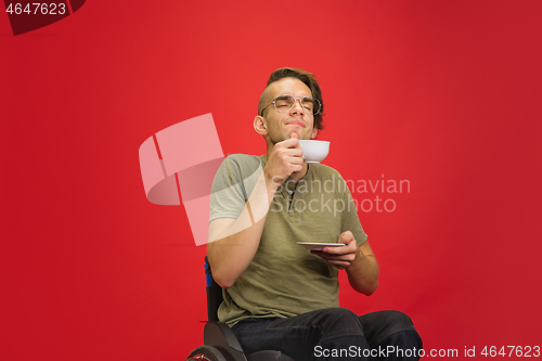 Image of Caucasian young man\'s portrait isolated on red studio background. Human emotions concept