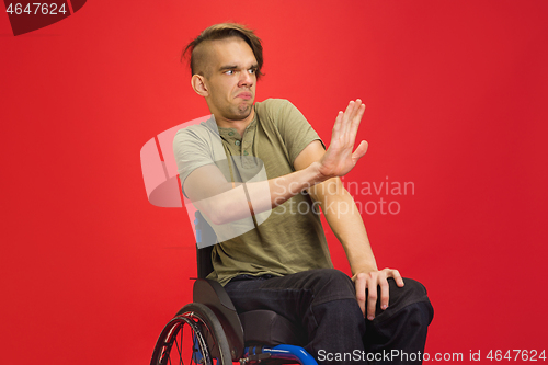 Image of Caucasian young man\'s portrait isolated on red studio background. Human emotions concept