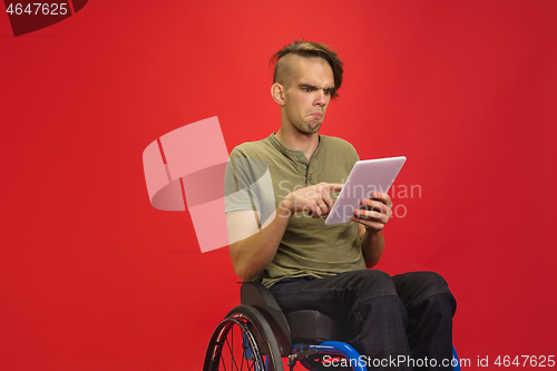 Image of Caucasian young man\'s portrait isolated on red studio background. Human emotions concept