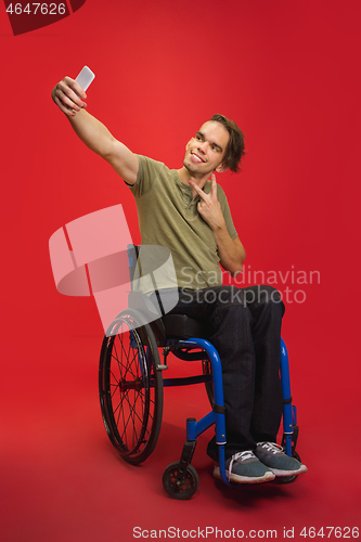 Image of Caucasian young man\'s portrait isolated on red studio background. Human emotions concept