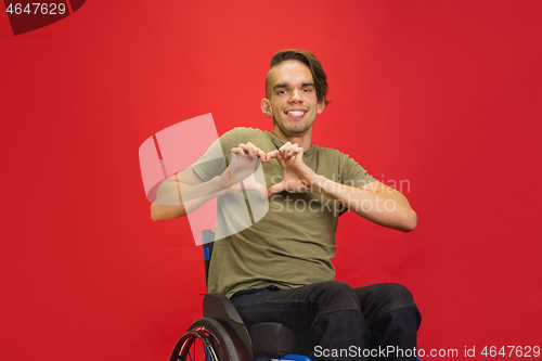 Image of Caucasian young man\'s portrait isolated on red studio background. Human emotions concept