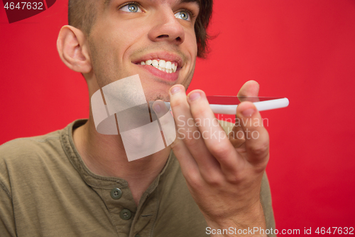 Image of Caucasian young man\'s portrait isolated on red studio background. Human emotions concept