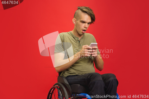 Image of Caucasian young man\'s portrait isolated on red studio background. Human emotions concept