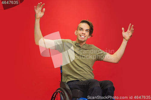 Image of Caucasian young man\'s portrait isolated on red studio background. Human emotions concept