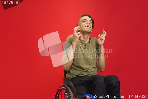 Image of Caucasian young man\'s portrait isolated on red studio background. Human emotions concept