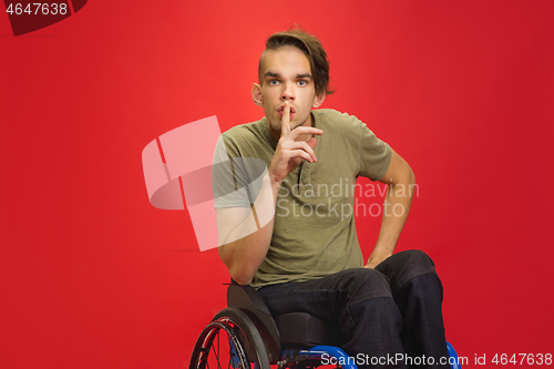 Image of Caucasian young man\'s portrait isolated on red studio background. Human emotions concept