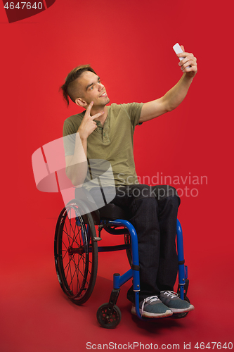 Image of Caucasian young man\'s portrait isolated on red studio background. Human emotions concept