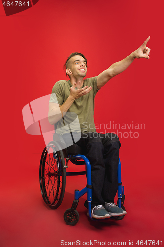 Image of Caucasian young man\'s portrait isolated on red studio background. Human emotions concept