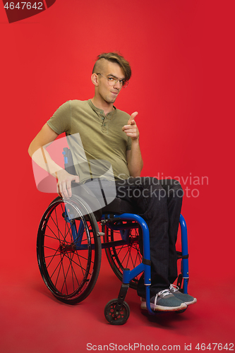 Image of Caucasian young man\'s portrait isolated on red studio background. Human emotions concept