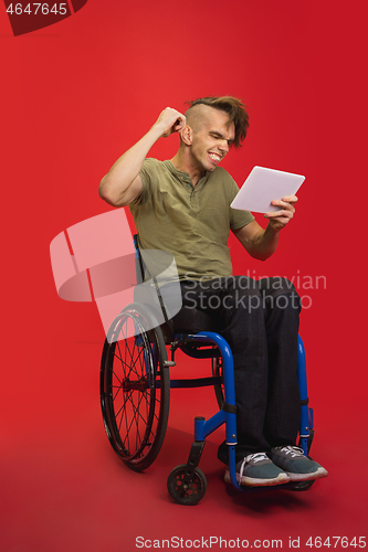 Image of Caucasian young man\'s portrait isolated on red studio background. Human emotions concept