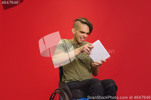 Image of Caucasian young man\'s portrait isolated on red studio background. Human emotions concept