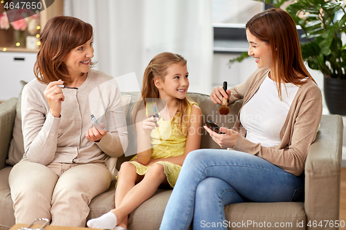 Image of mother, daughter and grandmother doing make up