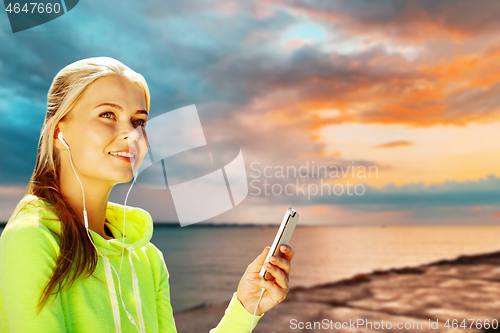 Image of woman listening to music on smartphone at seaside