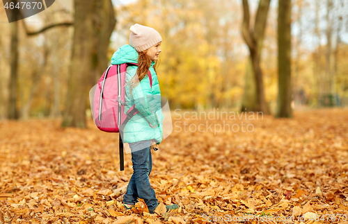 Image of happy student girl with schoolbag at autumn park
