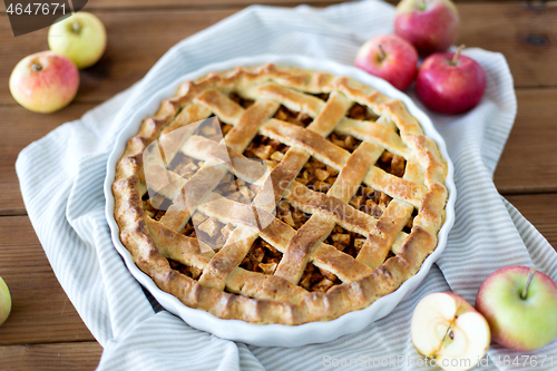 Image of apple pie in baking mold on wooden table